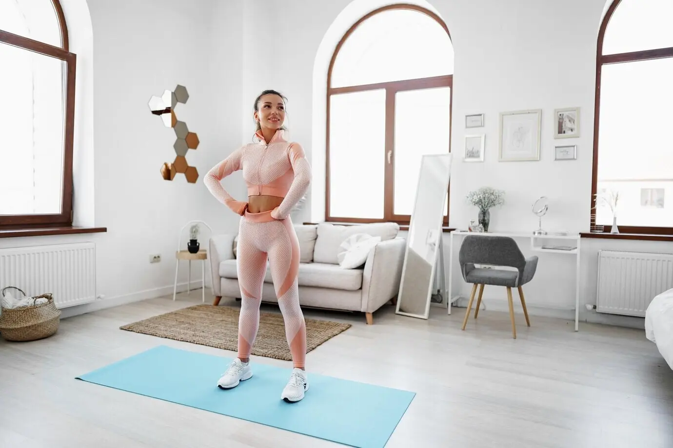 Junges Mädchen führt Sportübungen in ihrem Wohnzimmer zu Hause aus.